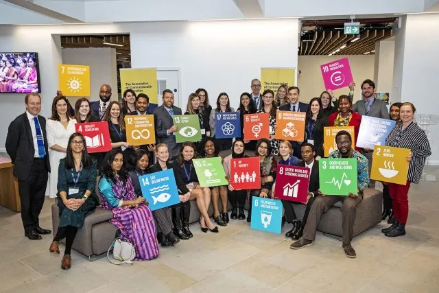 Staff, scholars and members of the Association of Commonwealth Universities holding placards relating to the Sustainable Development Goals