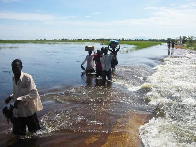 African children walking through a flooded field
