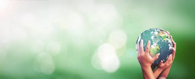 Young and hold hands holding up a globe in a green background
