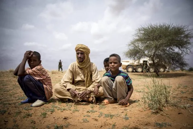 Three children civilians sitting on floor