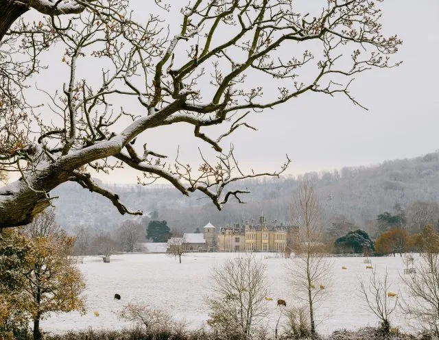 Wiston House is viewed from afar on a snowy day.
