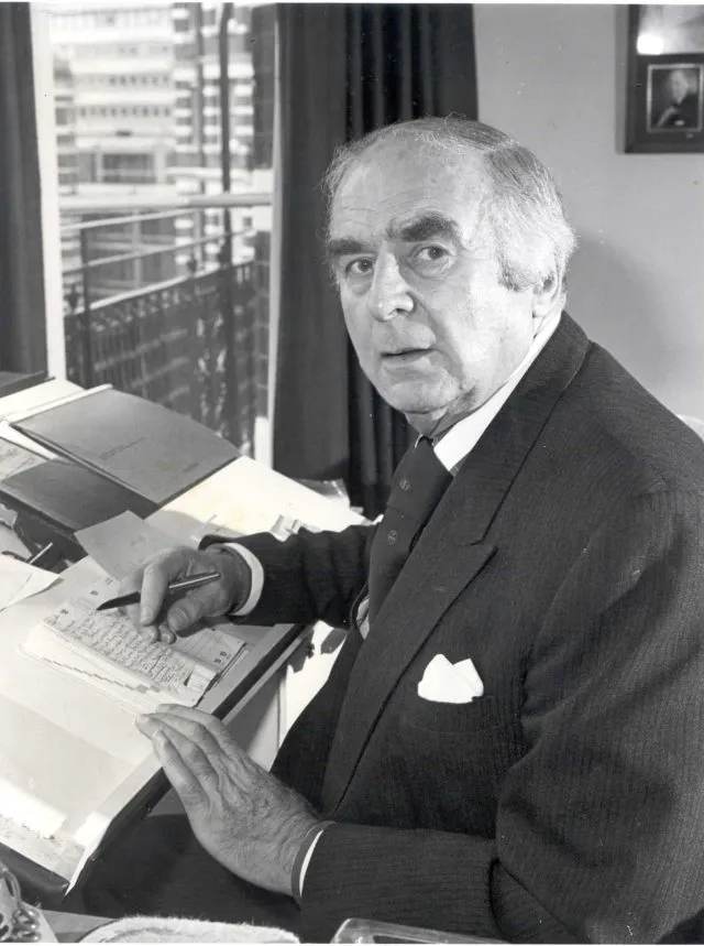 Heinz Koeppler sits at a desk