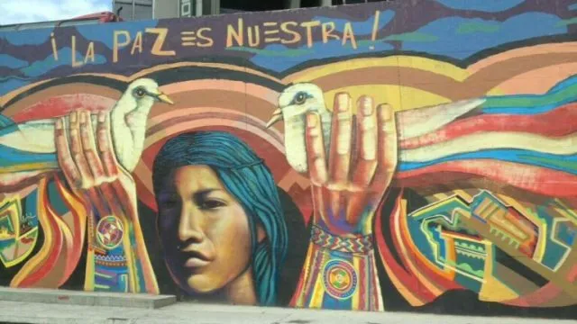 Street art displaying a woman holding two doves to signify peace