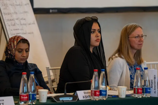 Amani Al-Khatahtbeh , founder and director of MuslimGirl, sits at the conference table with Shahin Ashraf, head of global advocacy at Islamic Relief Worldwide and Lorna Gold, Board Chair of Laudato Si'
