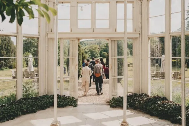 Guests wander out of the orangery at Wilton Park.