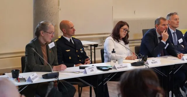 Uk Ambassador to Sweden, Samantha Job, sits at the conference table