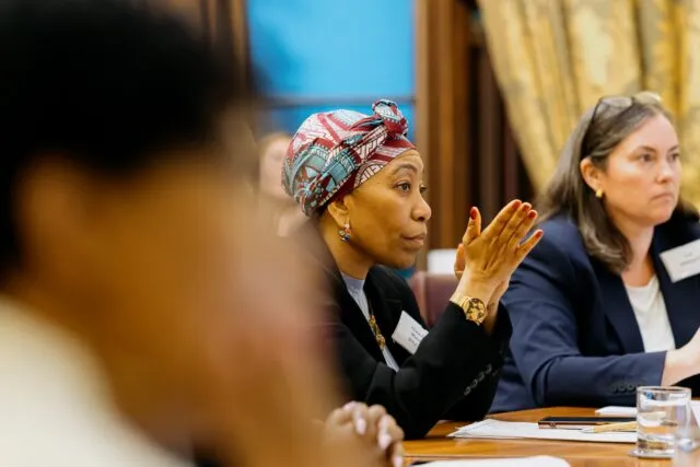 A participant watches the conversation in the conference room