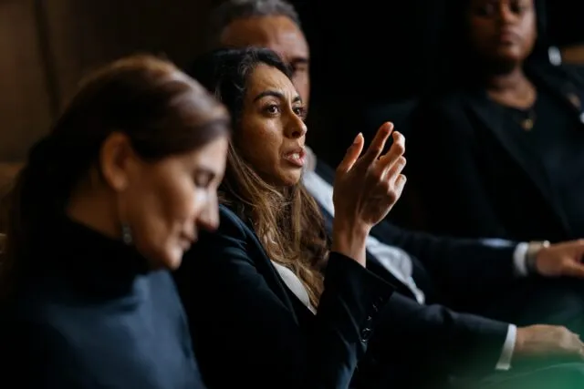 A participant raises her hand as she speaks