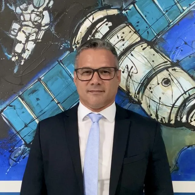 A headshot of Luis Felipe de Moura Nohra, looking at the camera. He is wearing a dark suit jacket and pale blue tie.