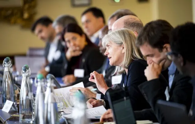 Alison Hilliard speaks at the conference table