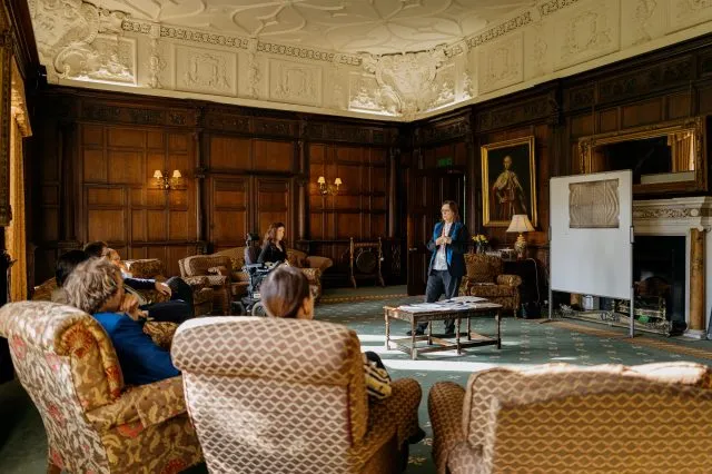Participants seated in the common room watch a historical talk