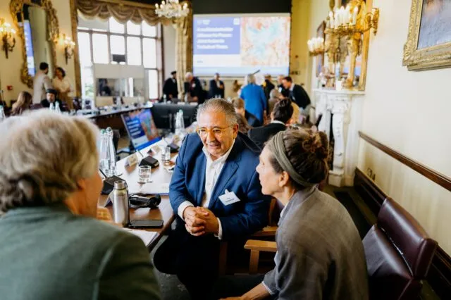 A group of participants in discussion at the conference table
