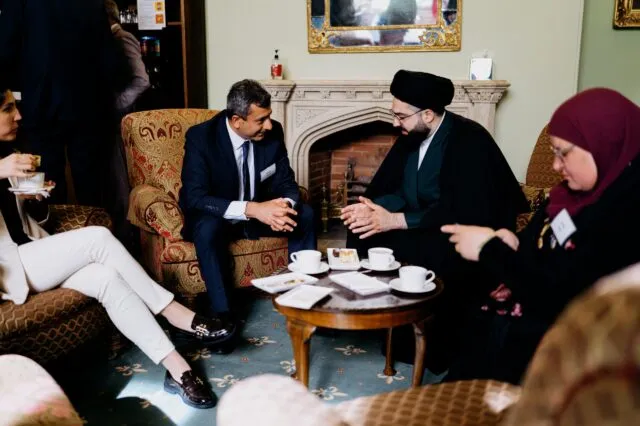 Two participants in discussion over tea in the green room
