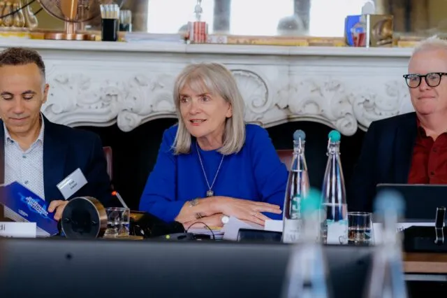 Alison Hilliard speaks at the conference table