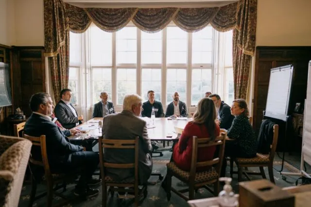 A participant speaking to a group of people during a breakout session at the Wilton Park dialogue on Mid-market companies: growth and resilience.